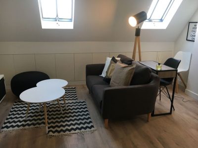 Décoration d'un salon dans un style scandinave, optimisation de l'espace avec l'intégration d'un espace bureau.