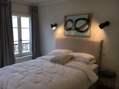 Décoration d'une chambre haussmannienne chaleureuse, à la tête de lit sublimée par un tableau Notre Monde.